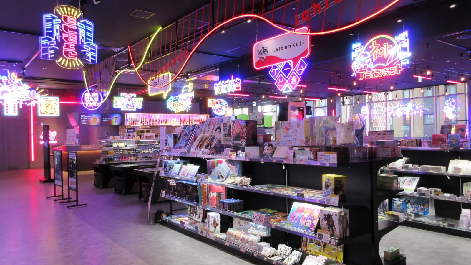 A neon-lit ichiban kuji sales floor inside Namco TOKYO, with rows of prize displays under glowing signage.